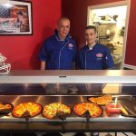 Worker making fresh pizza at USA Pizza Town