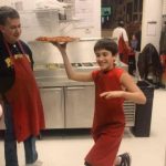 Worker making fresh pizza at USA Pizza Town